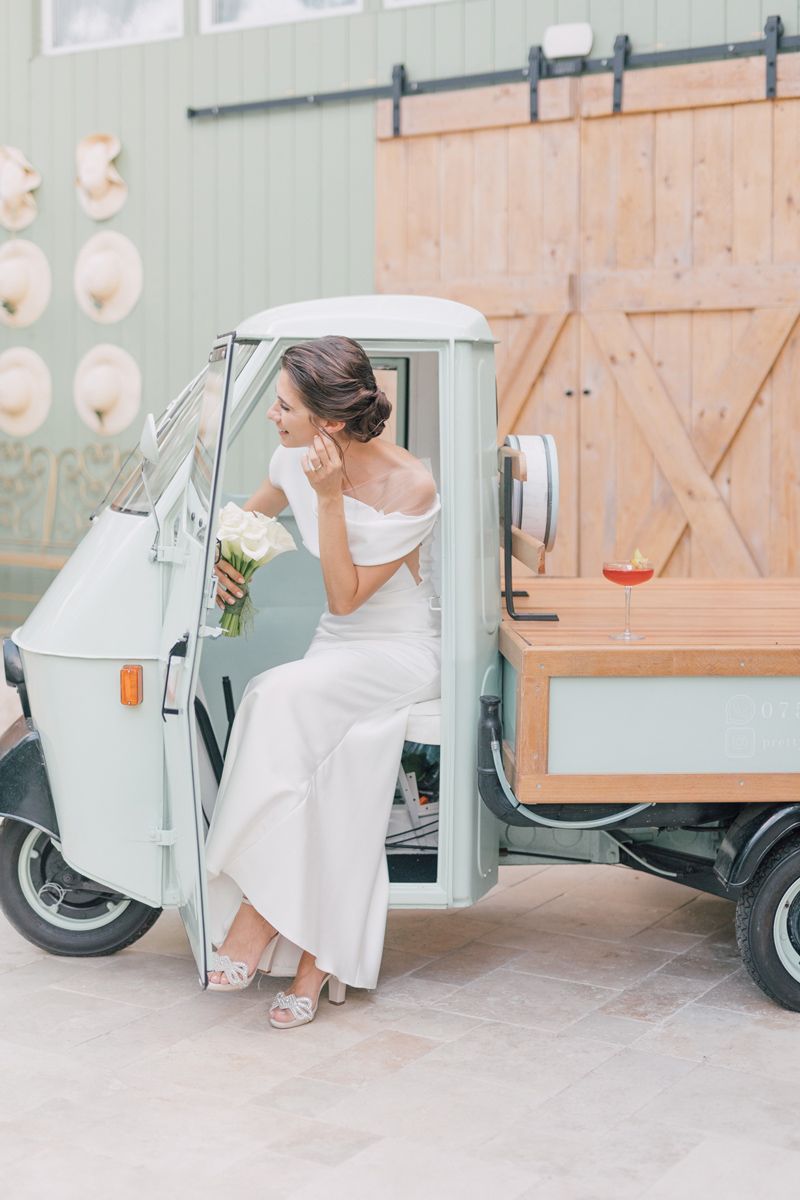 A vintage mint green Vespa scooter serves as a stylish wedding day photo prop against a rustic backdrop.