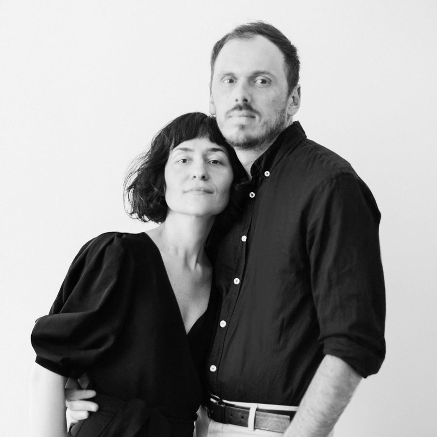 Black and white photo series showing a couple in dark clothing posing together against a light background.