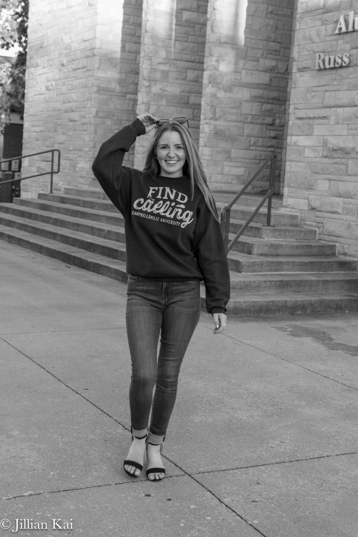 Young woman in Find Your Calling Campbellsville University sweatshirt posing in black and white photo.