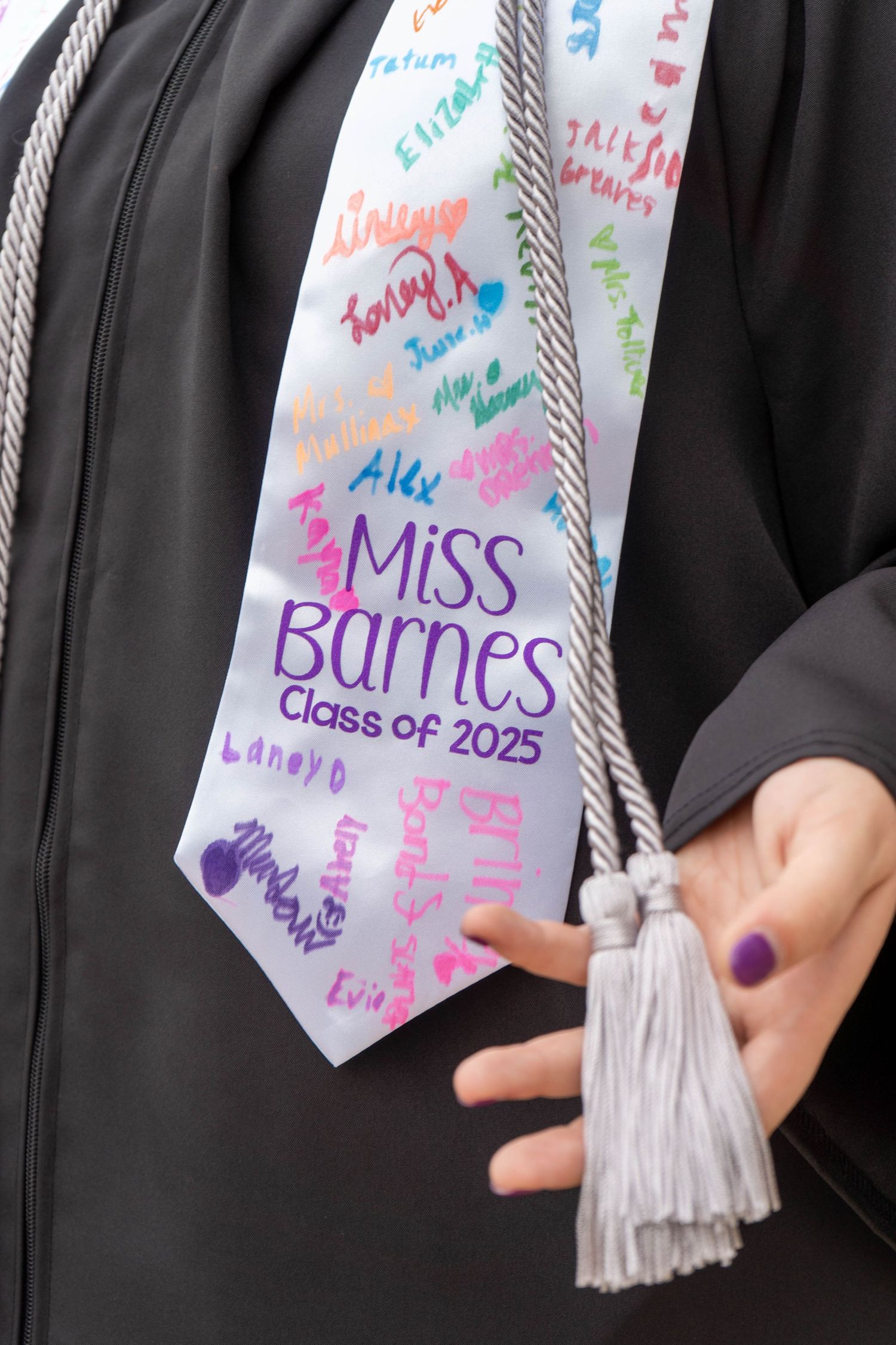 Close-up of Miss Barnes Class of 2025 graduation stole signed by students.