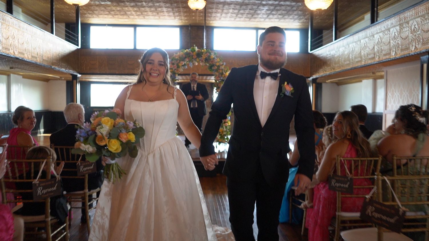 Bride and groom walking down the aisle hand in hand after their wedding ceremony.