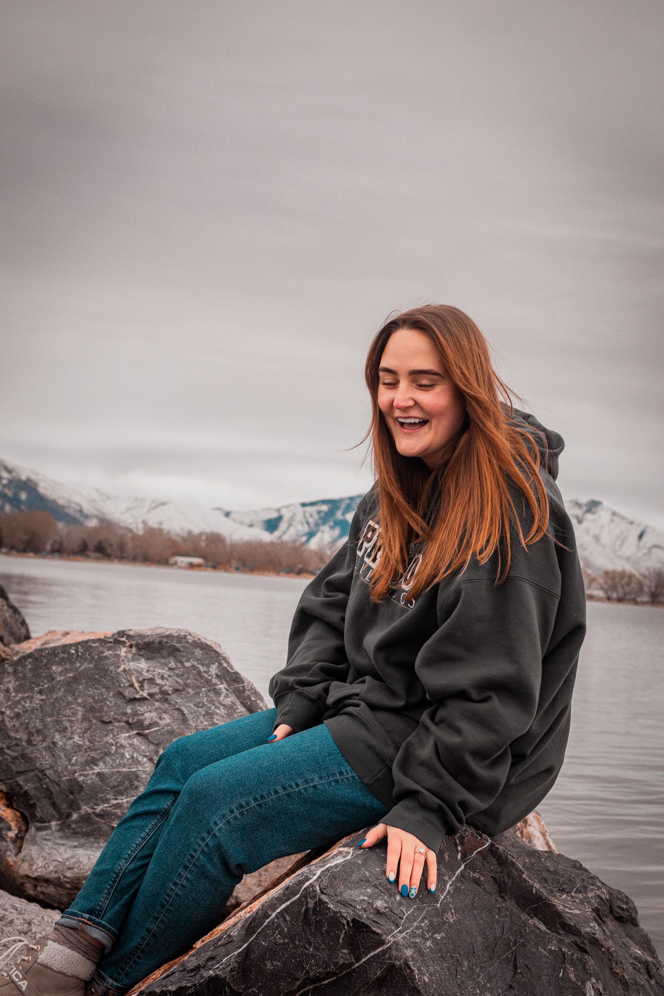 Cute sitting portrait of woman next to lake in Utah
