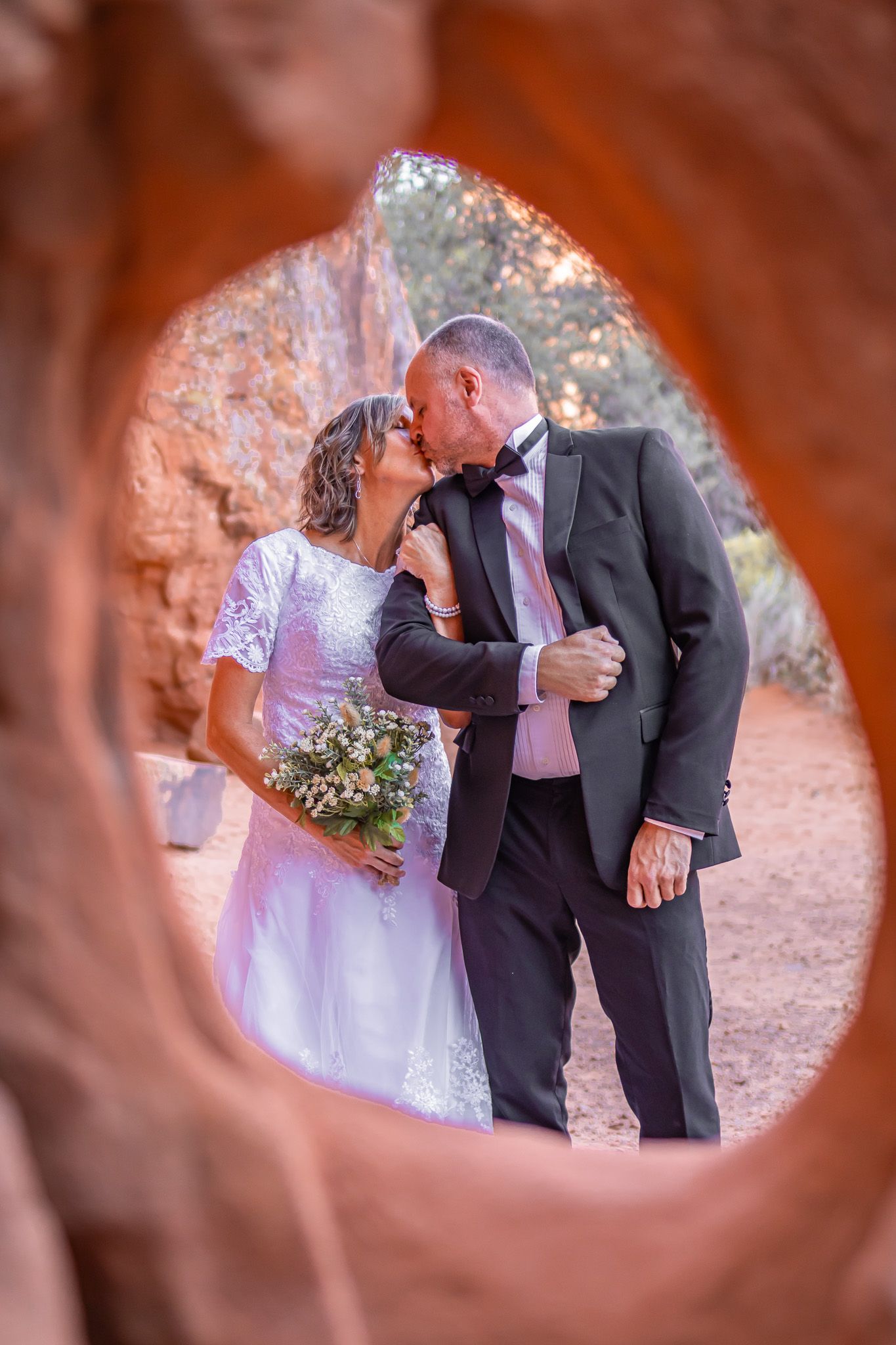 Bride and Groom with red rock framing at Snow Canyon in Utah