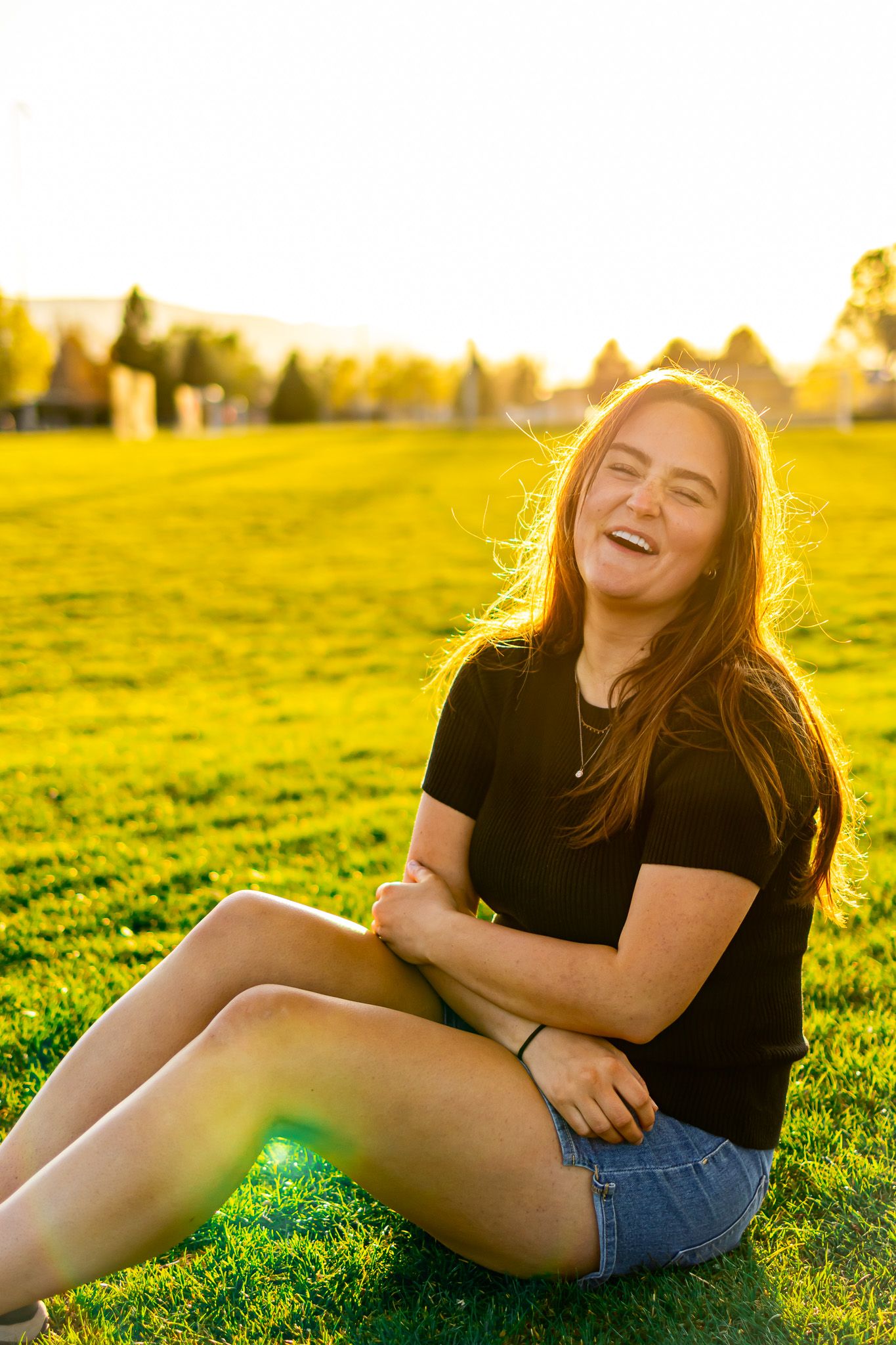 Cute sitting portrait of woman at park in Utah with green background