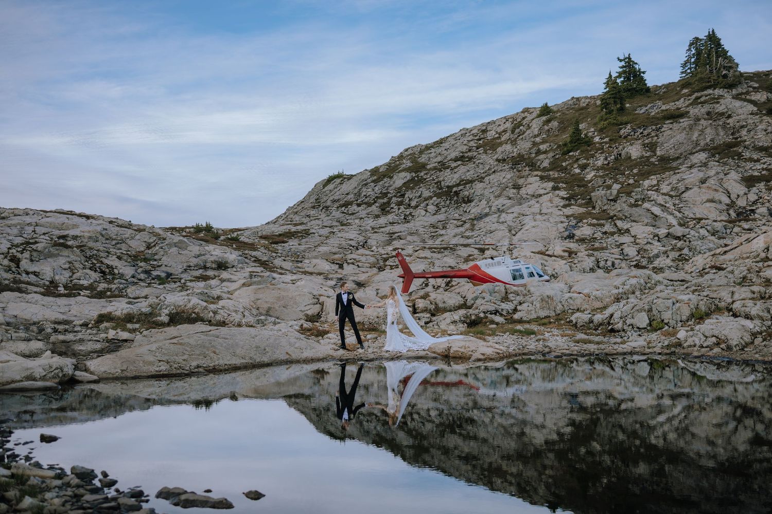 a bride and groom by the mountains and lake outside of Campbell river on a helicopter tour with 49 north helicopters