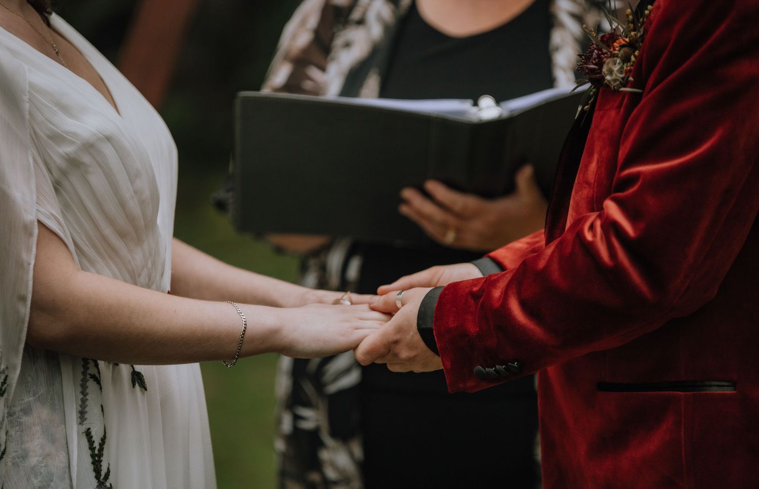 Hands exchanging a diploma during a graduation ceremony in traditional academic regalia.