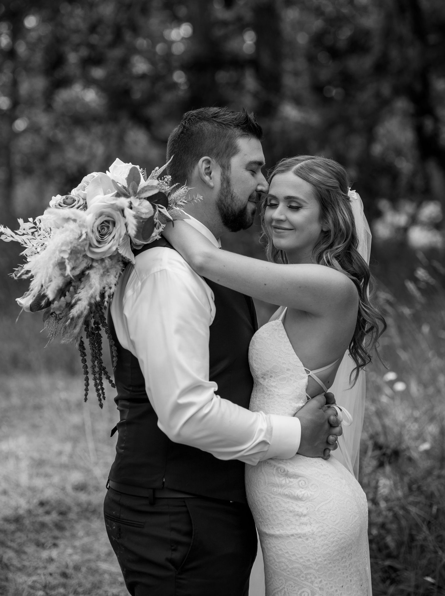 A romantic wedding photo series showing a couple embracing and dancing in an outdoor garden setting at their wedding in Saanich BC