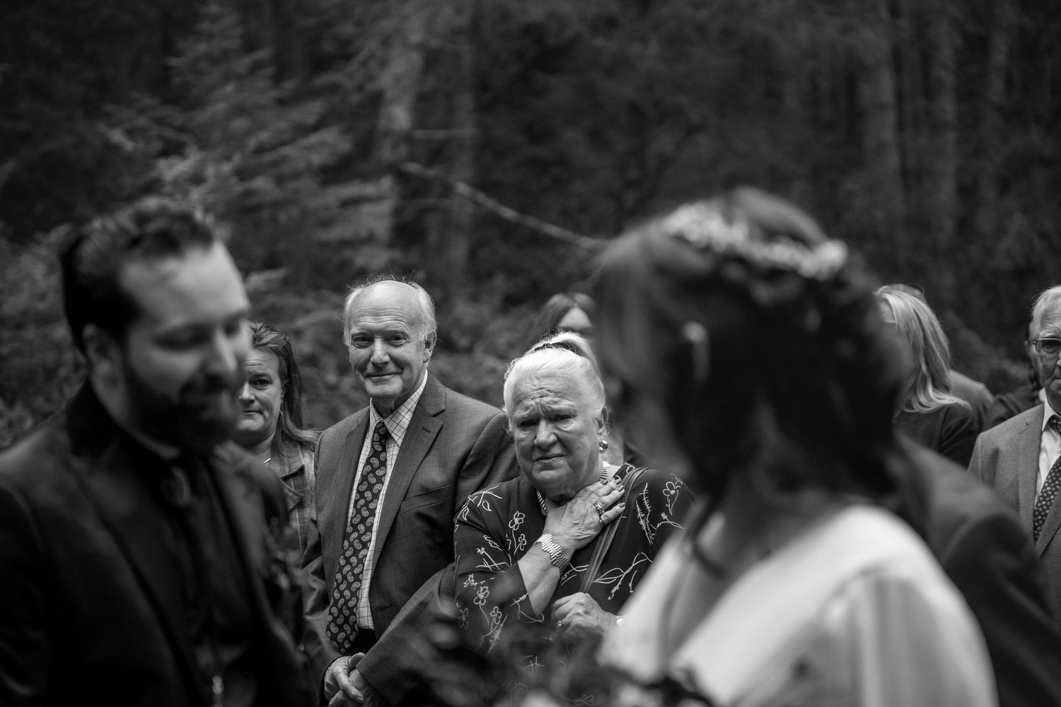 A series of black and white candid photos showing joyful laughter and emotional moments at a gathering in nature.