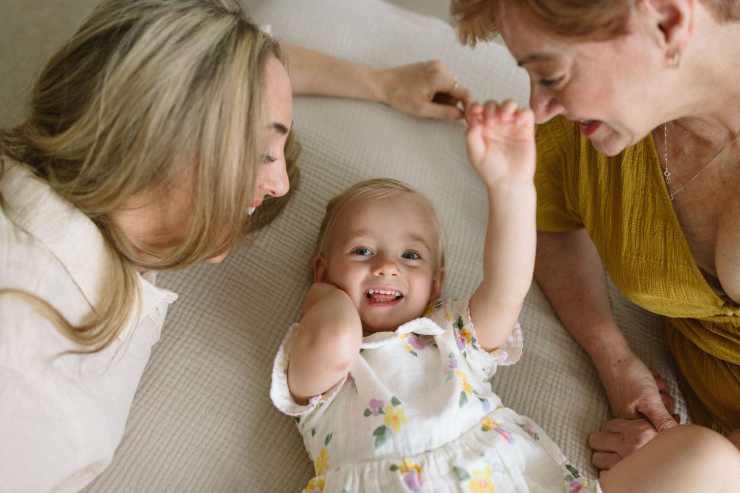 A playful moment shared on a comfortable couch with natural light streaming through the window.