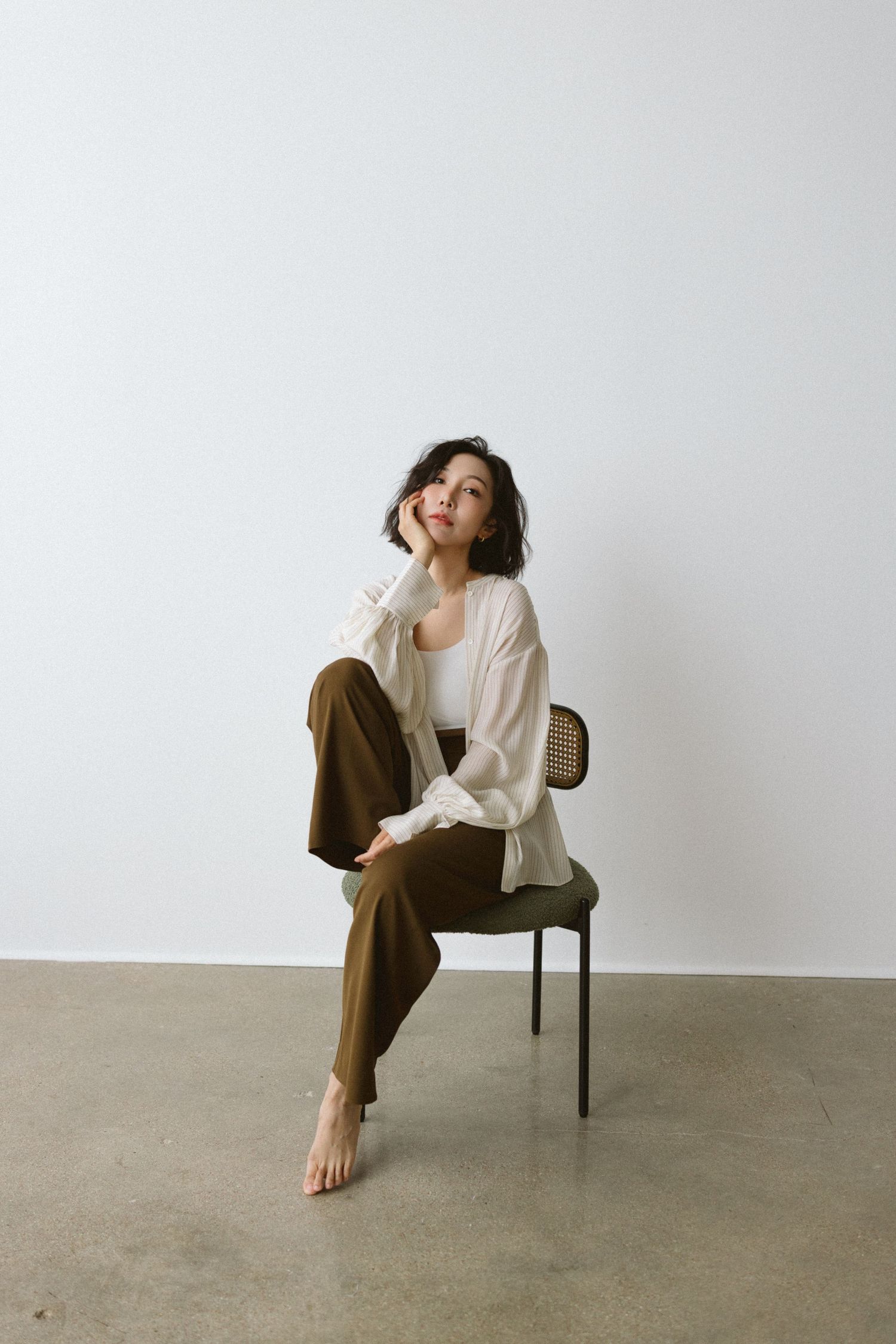 Minimalist photo series showing woman in casual clothing seated on chair against white background.
