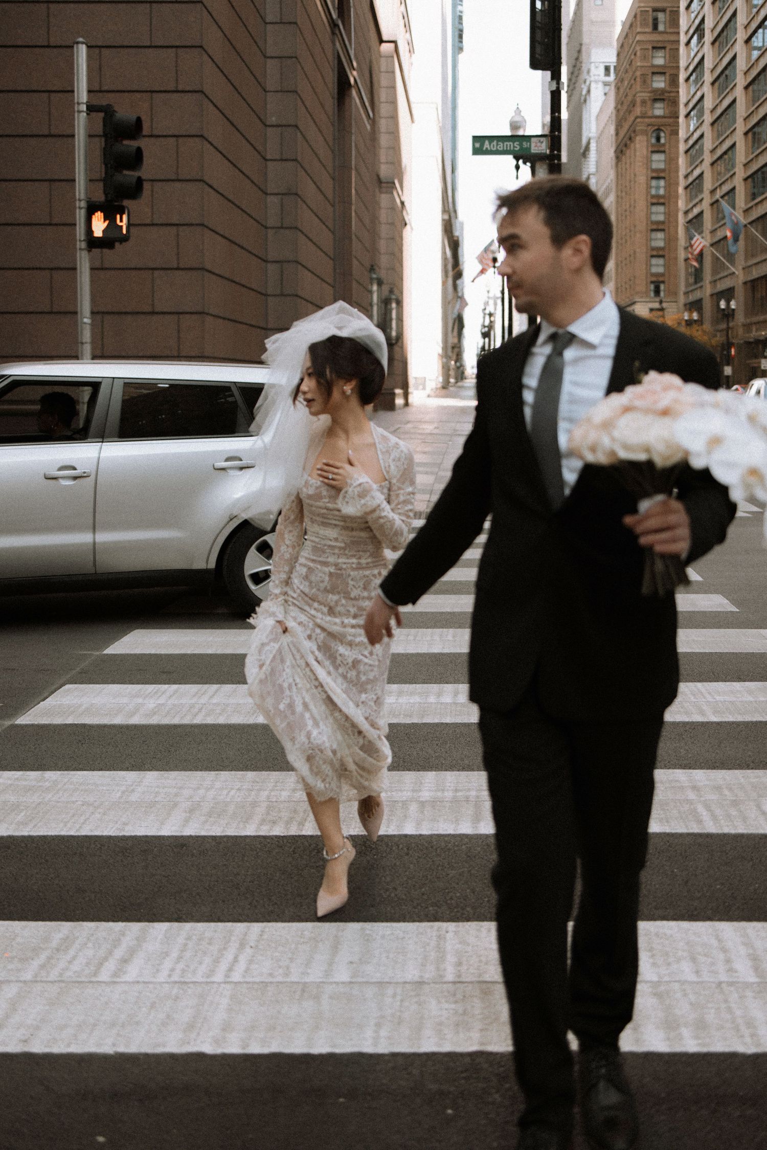 Sequence showing movement across an urban crosswalk in formal attire.