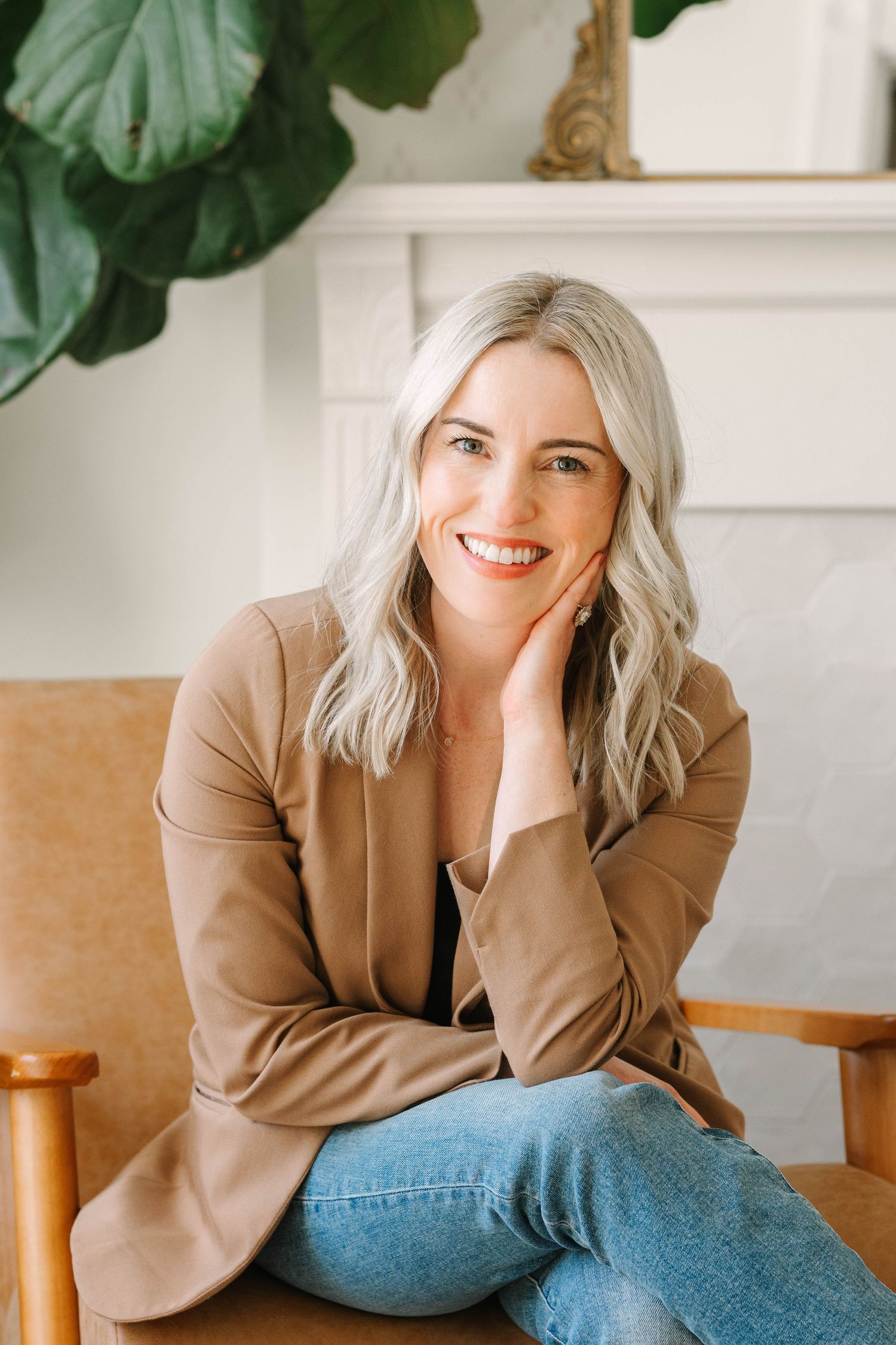 Professional lifestyle photo series showing relaxed poses in a brown blazer and jeans against a bright interior.