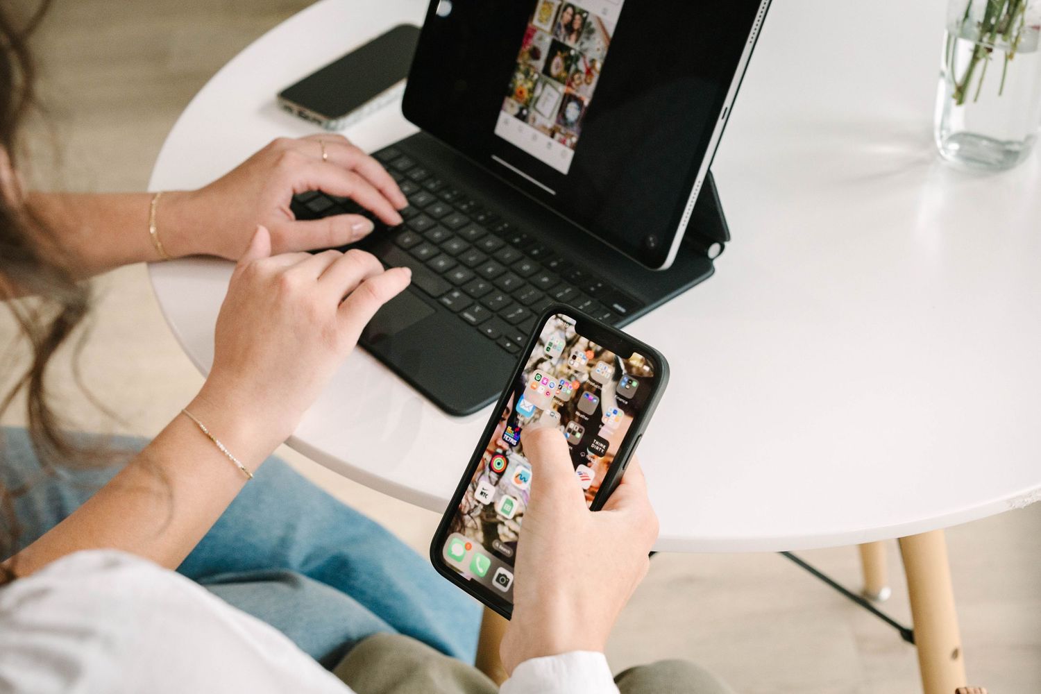 Desktop workspace setup with laptop and photo prints in modern office setting.