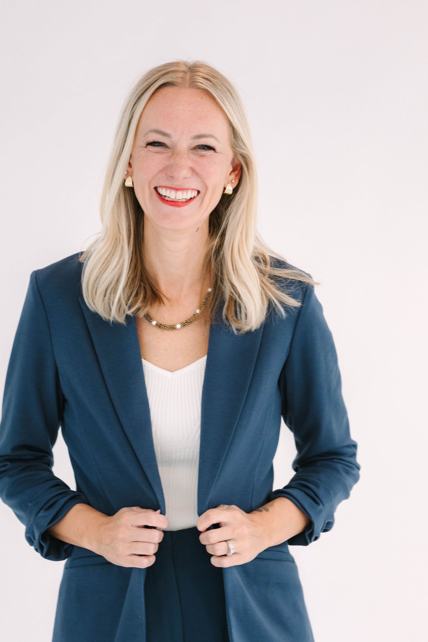 Professional headshots of woman in navy blazer against white background showing different expressions.