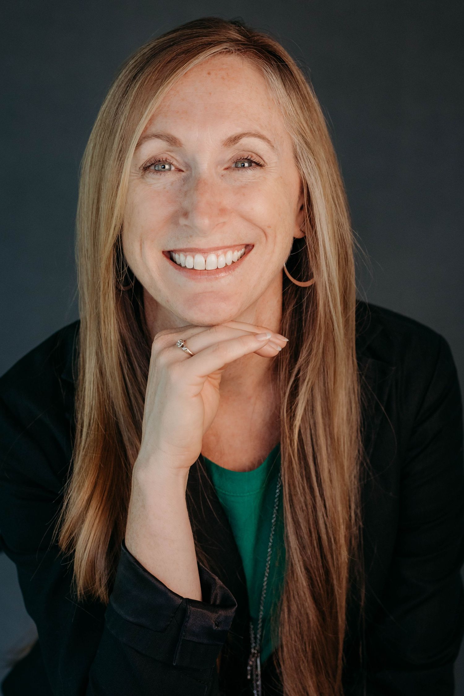 Casual portrait series showing relaxed poses and genuine laughter against dark backdrop.