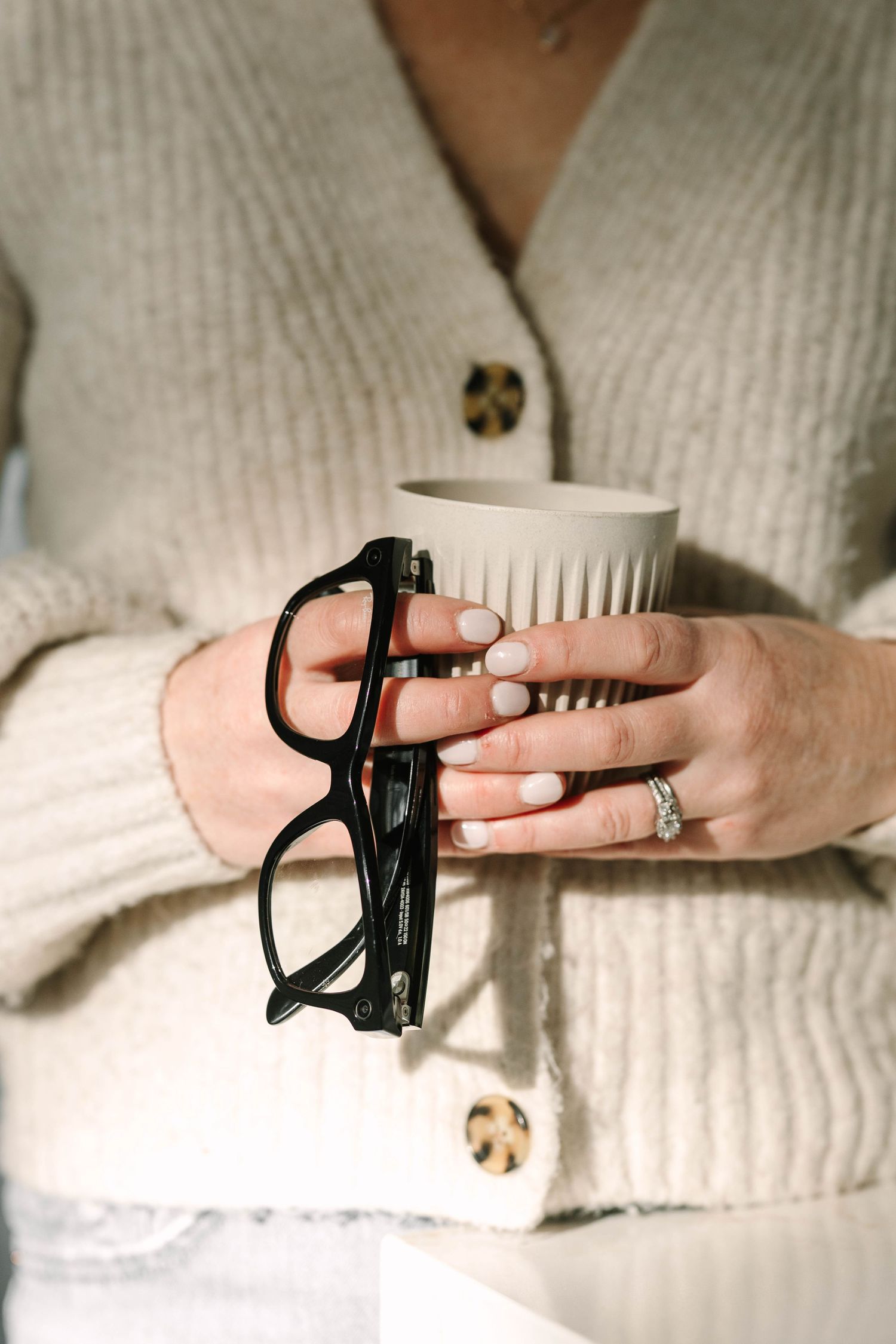 A sequence showing hands putting on a black finger splint or brace against a white textured background.