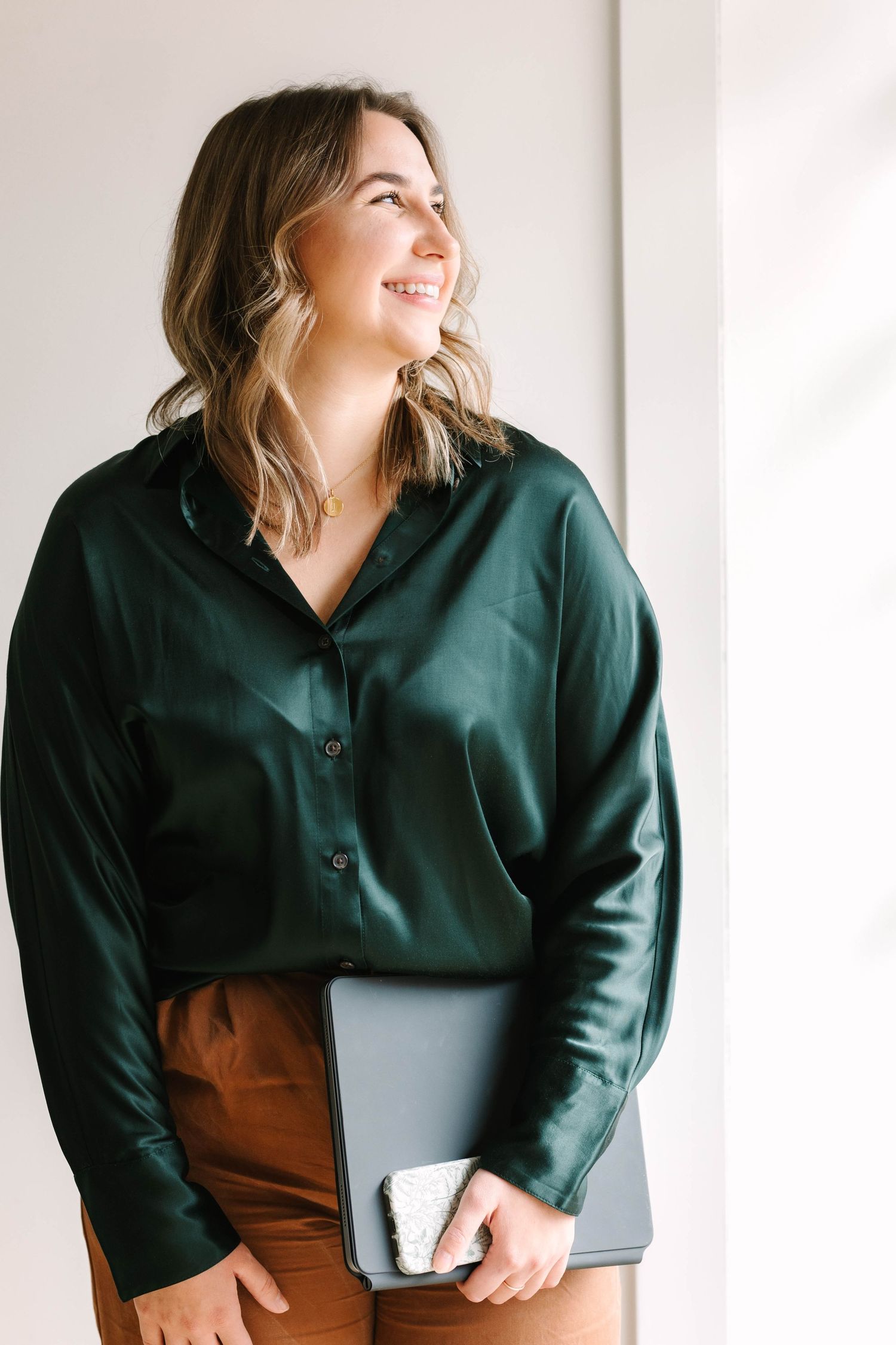 Professional business portrait series in emerald green blouse against white background.