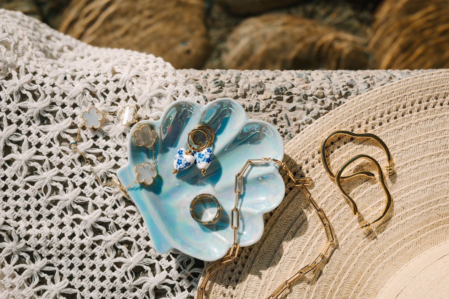 Close-up of delicate blue floral jewelry pieces on vintage lace background.