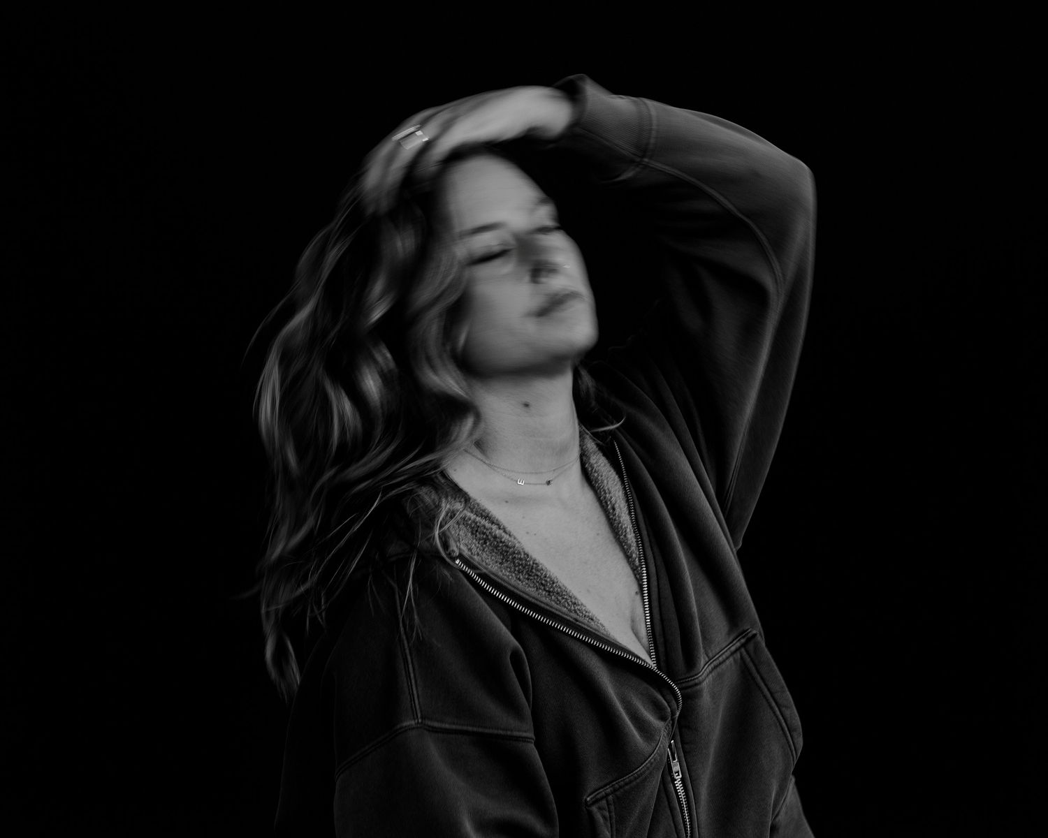 Moody black and white portrait with dramatic lighting and dark leather jacket.
