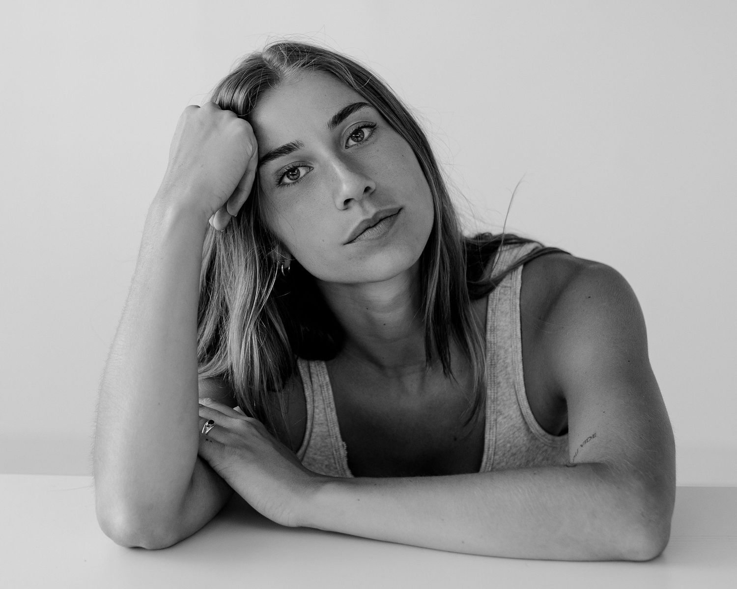 Series of artistic black and white portraits with soft lighting against light background.