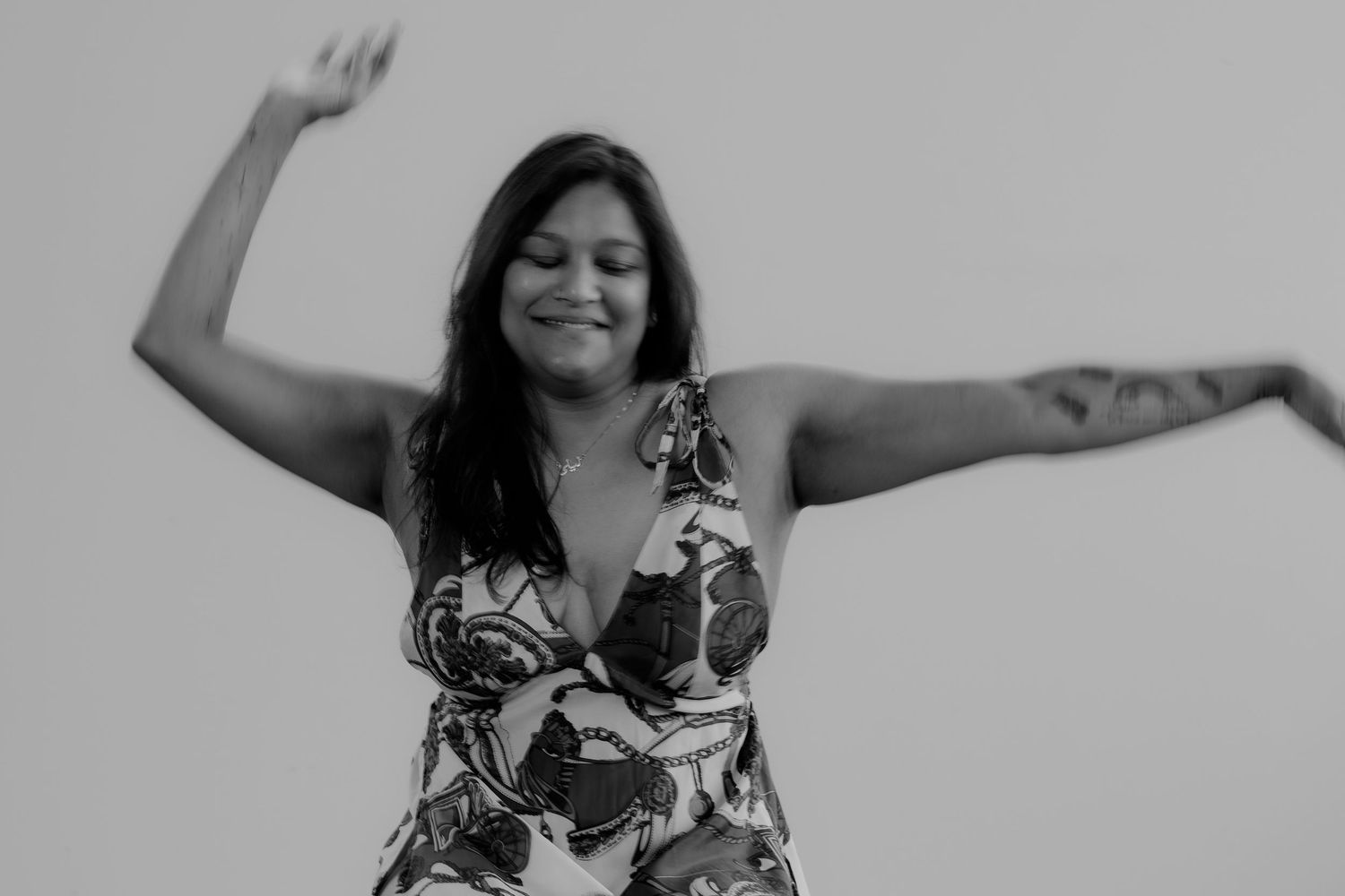 A person in patterned dress poses and dances in black and white photographic sequence.