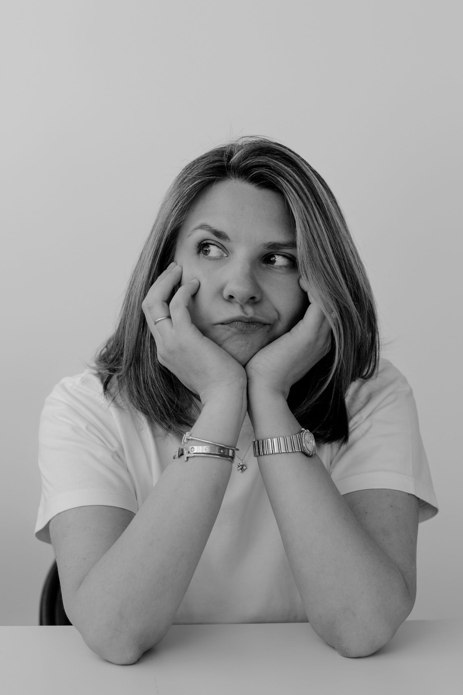 Black and white sequence showing contemplative poses with hands resting on cheeks.
