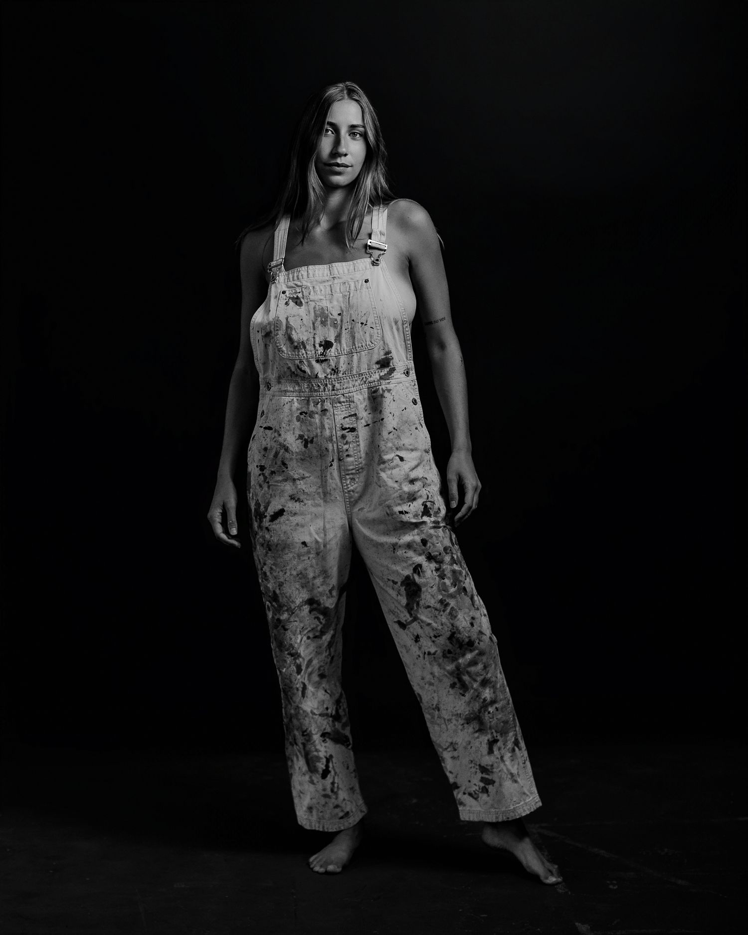 Black and white photos showing distressed overalls in artistic poses.