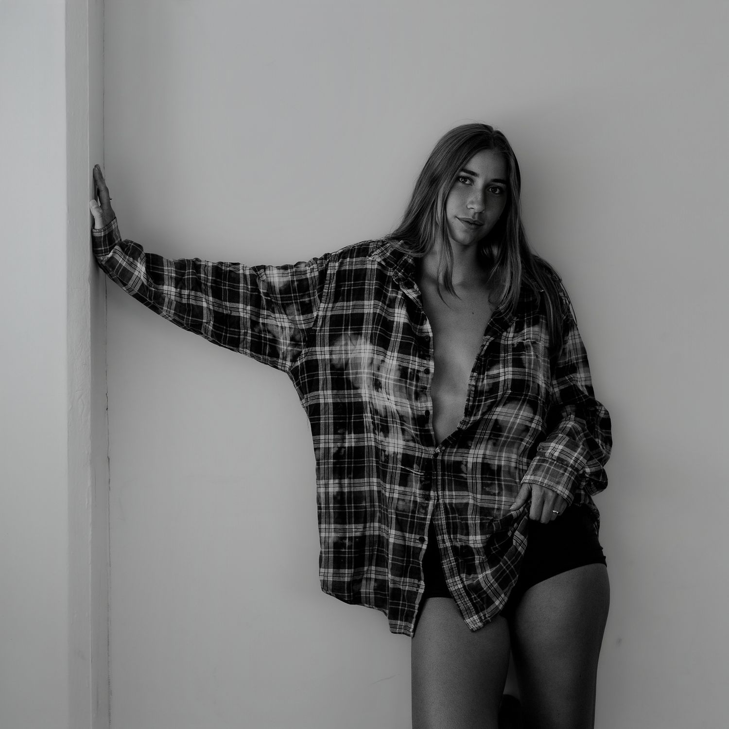 Artistic black and white photos of a figure wearing plaid shirt in various poses.