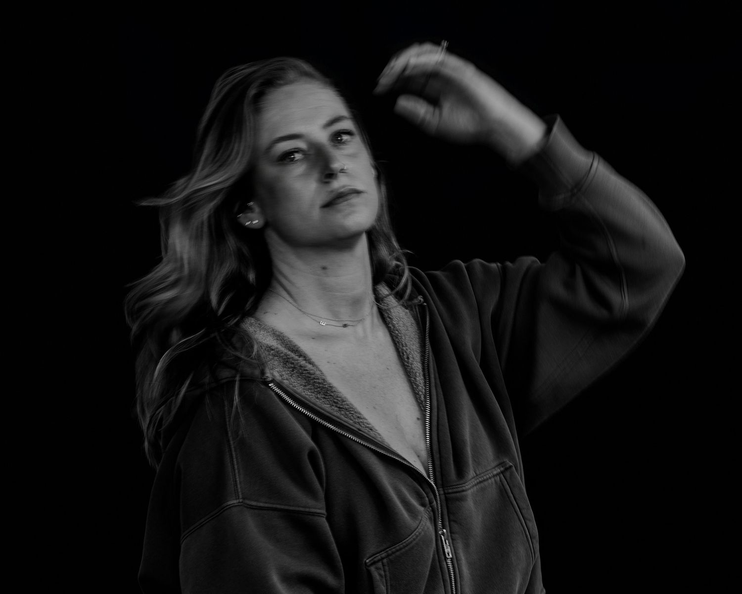 Artistic monochrome photograph showing figure in leather jacket against dark background.