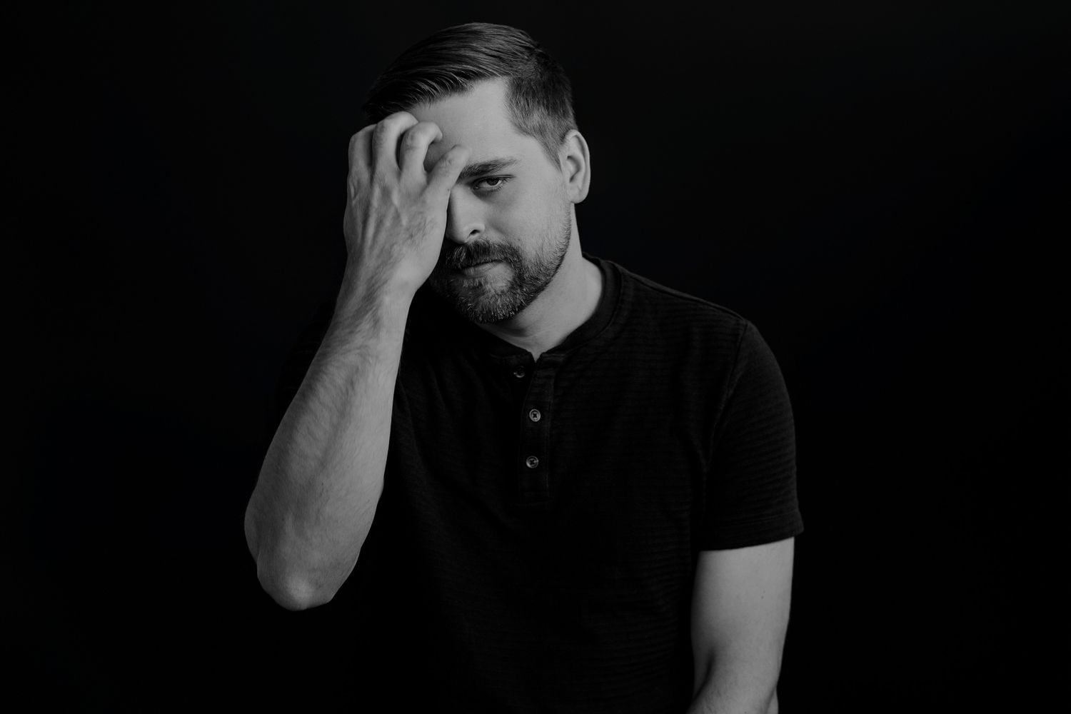 Emotive black and white portraits of person in dark polo showing contemplative expressions.
