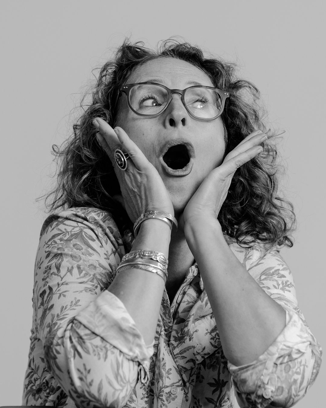 Sequence of expressive reactions and poses wearing glasses and floral print clothing.