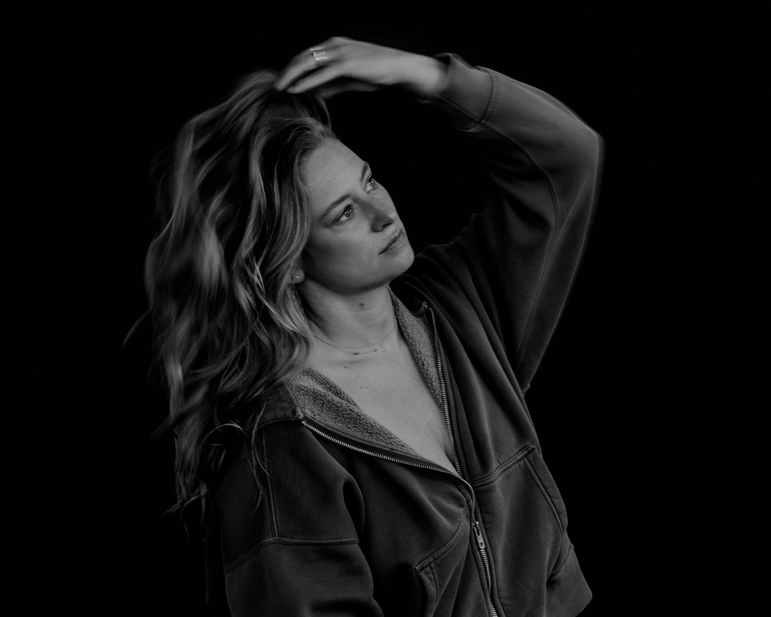 Expressive black and white fashion portrait with dark mood and lighting.