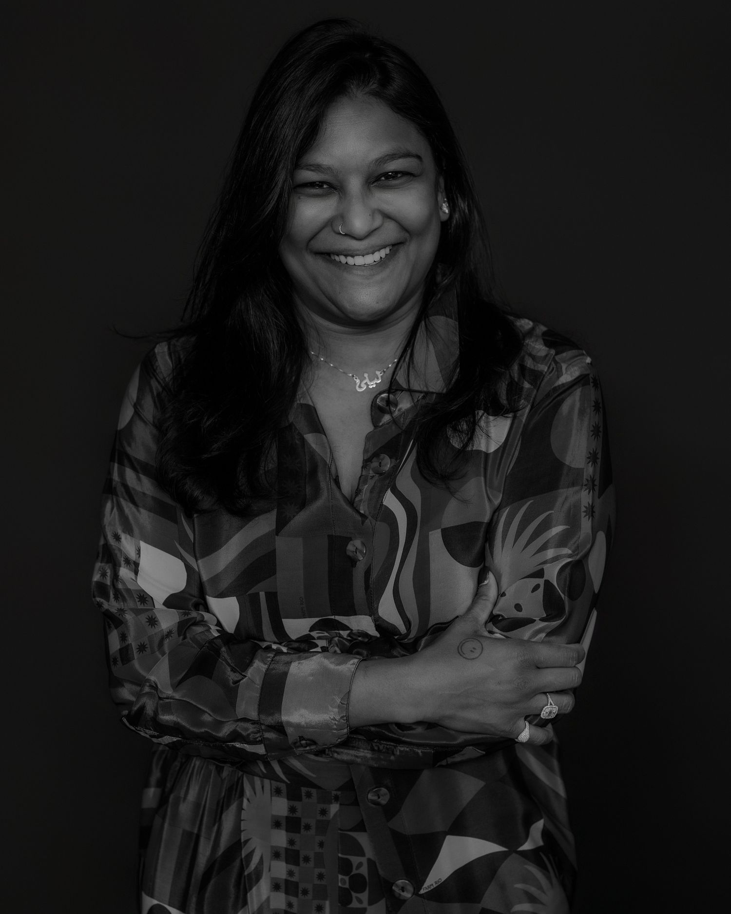 Portrait in low light showing joyful expression and floral patterned clothing.