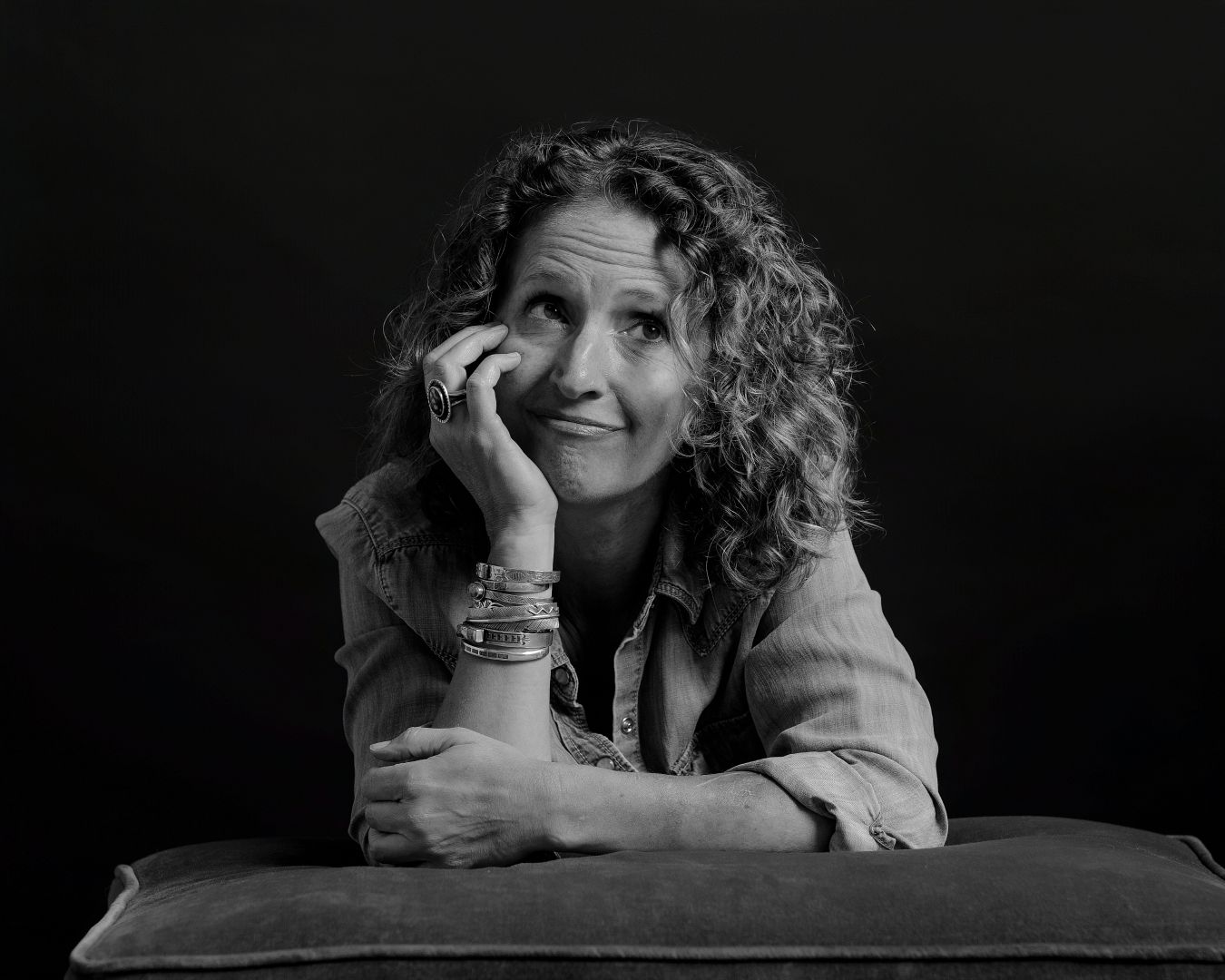 Black and white artistic portrait series showing reclining figure against dark background.