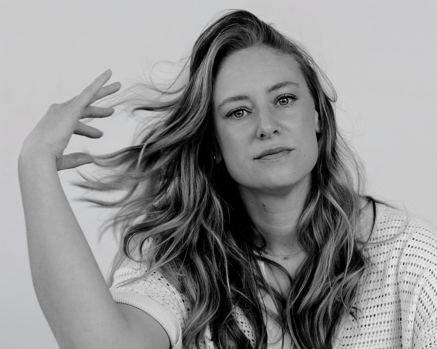 Person in white top showing different facial expressions in black and white portraits.