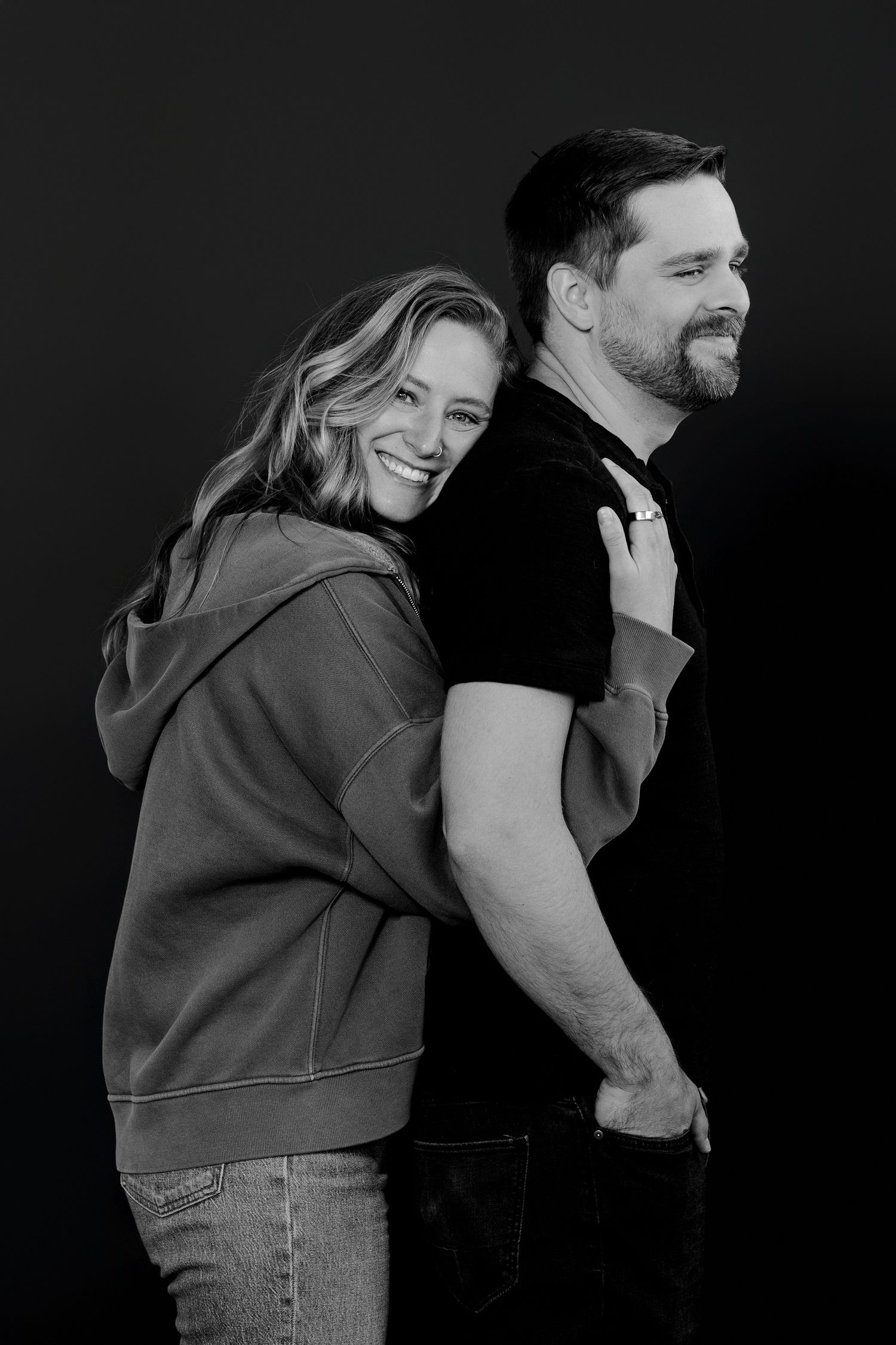 Black and white sequence of playful couple interactions against dark background.