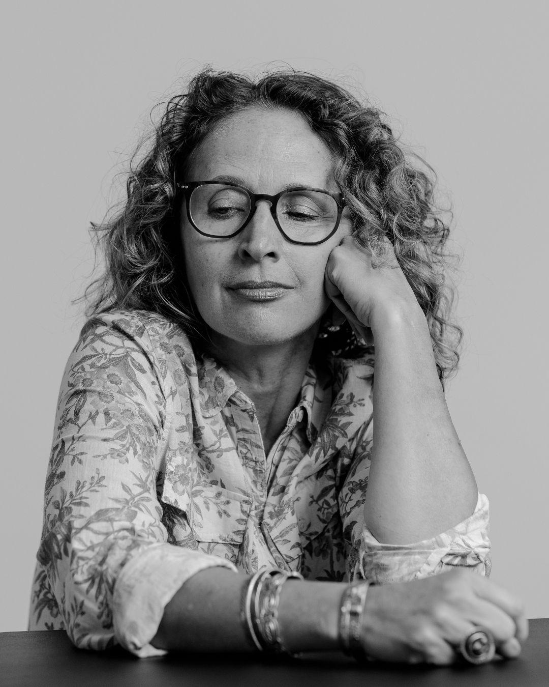 Black and white photo series of person in floral pattern top showing relaxed poses.