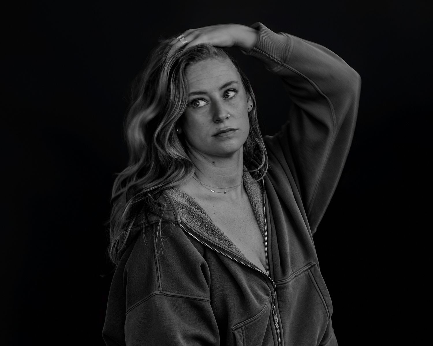 Expressive black and white studio portrait with figure in dark outfit.