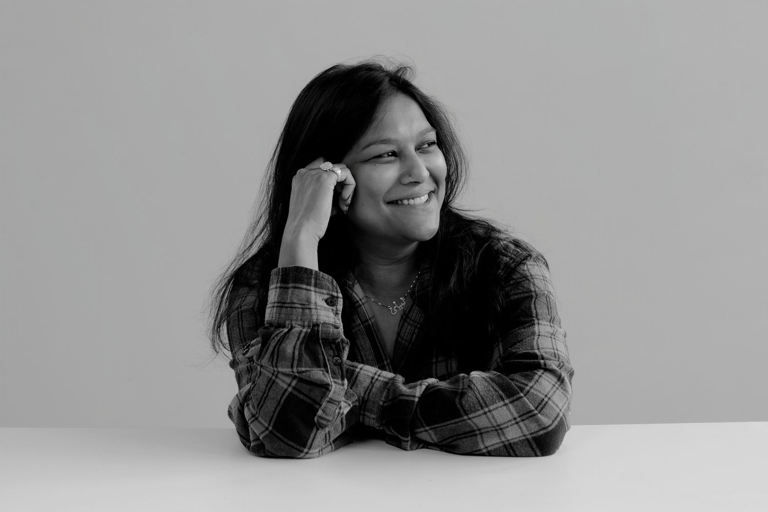 Figure in plaid shirt showing cheerful expressions while resting on surface.