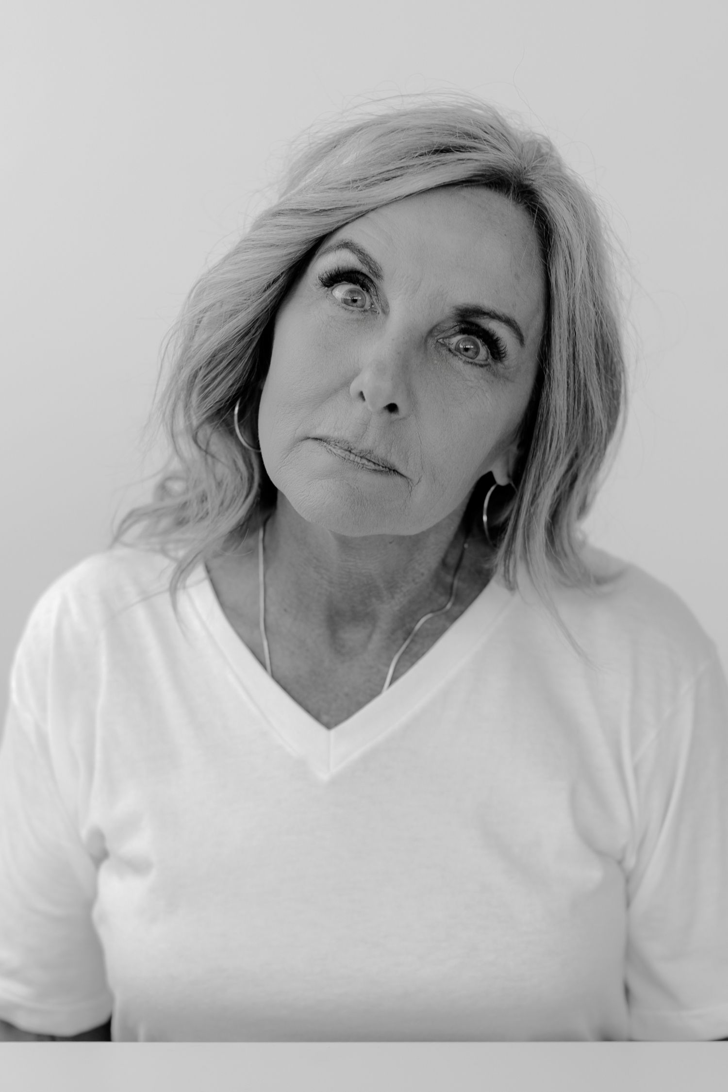 Black and white portrait sequence showing contemplative poses in white collared top.