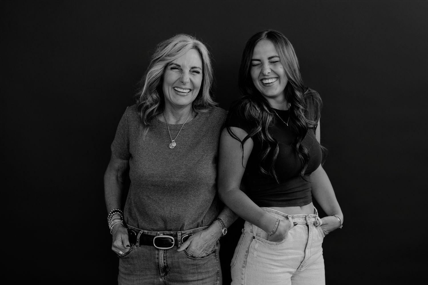 Candid black and white portrait of two women enjoying a playful moment together.