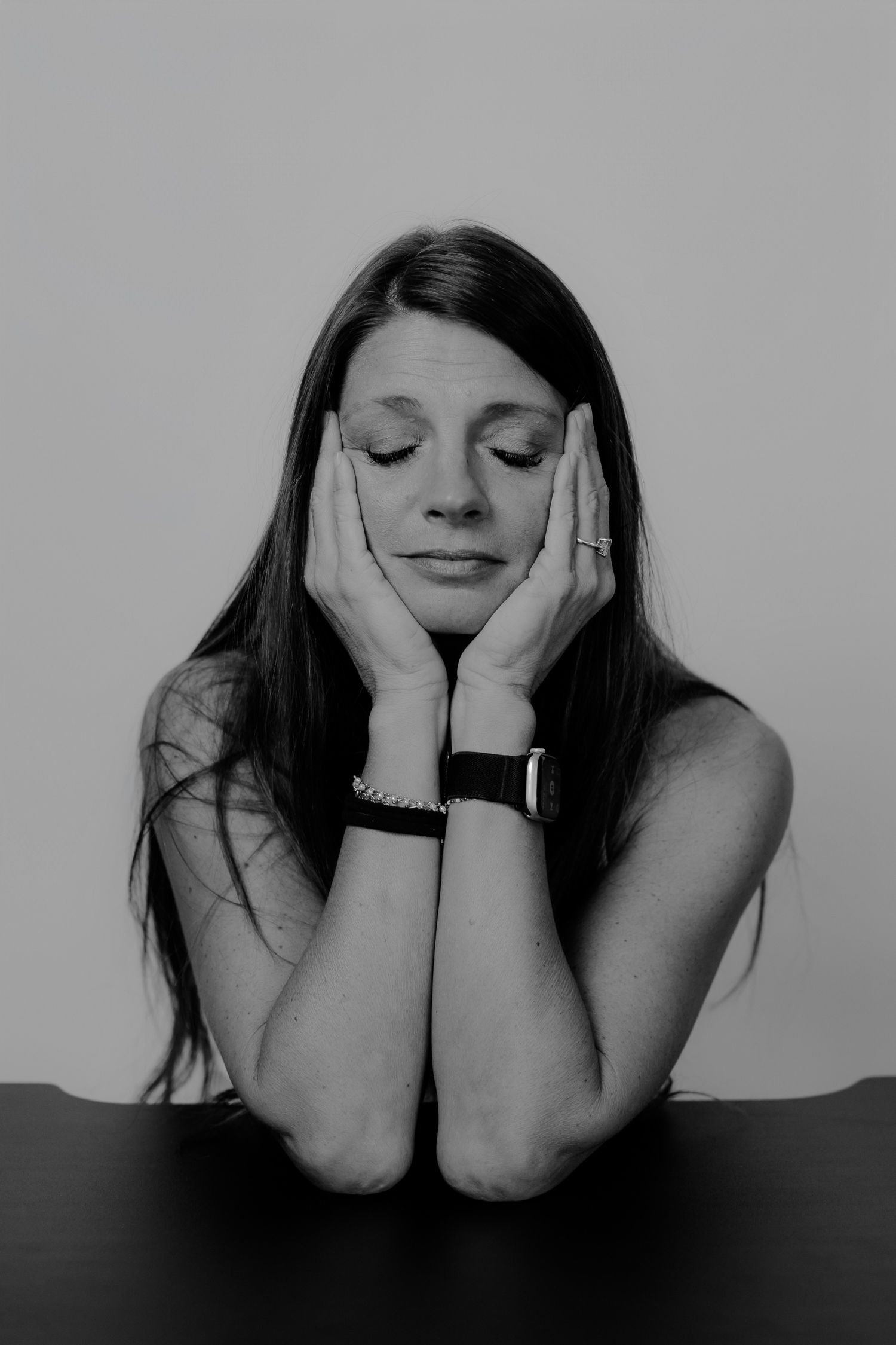Black and white photo series showing contemplative poses with hands framing the face.
