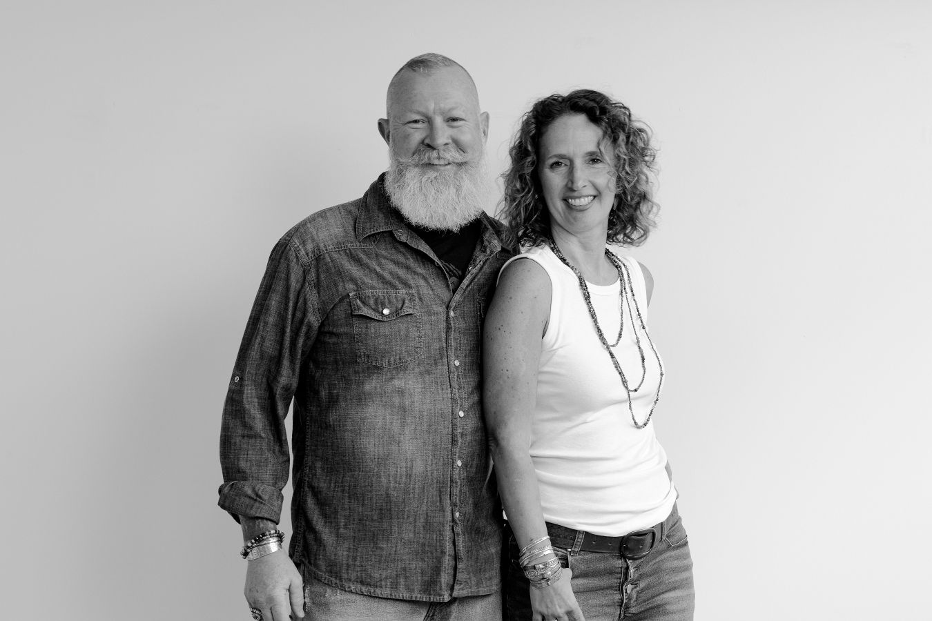 Candid black and white photograph of a couple sharing laughter and tender moment.