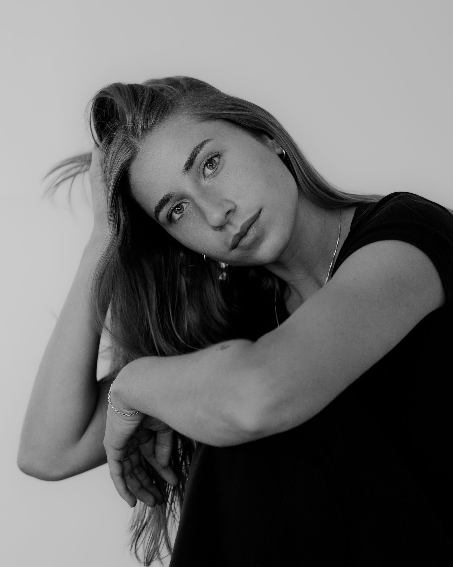 Artistic black and white portraits showing contemplative poses with dramatic lighting.