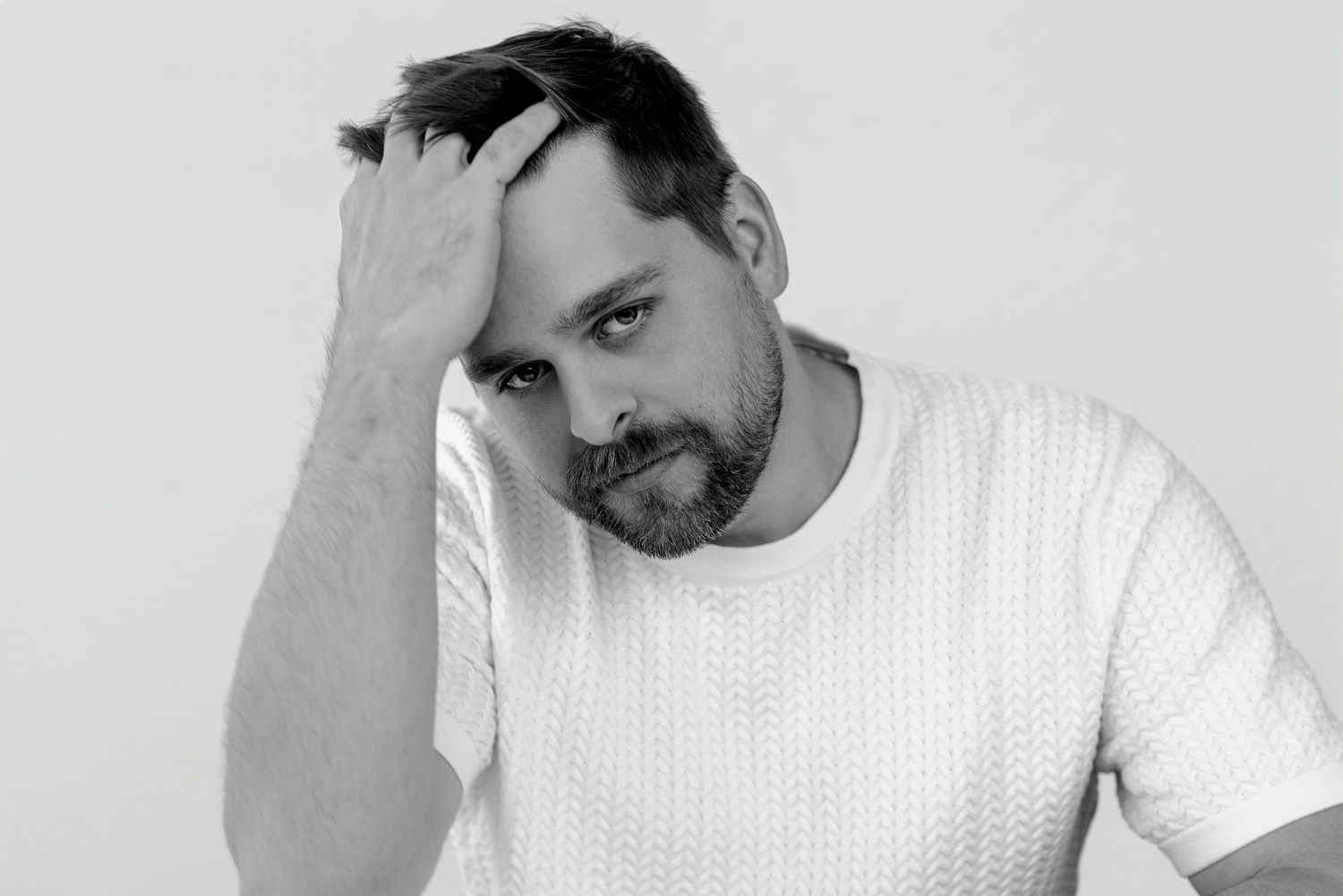 Person in white shirt displaying contemplative expressions in black and white portrait series.
