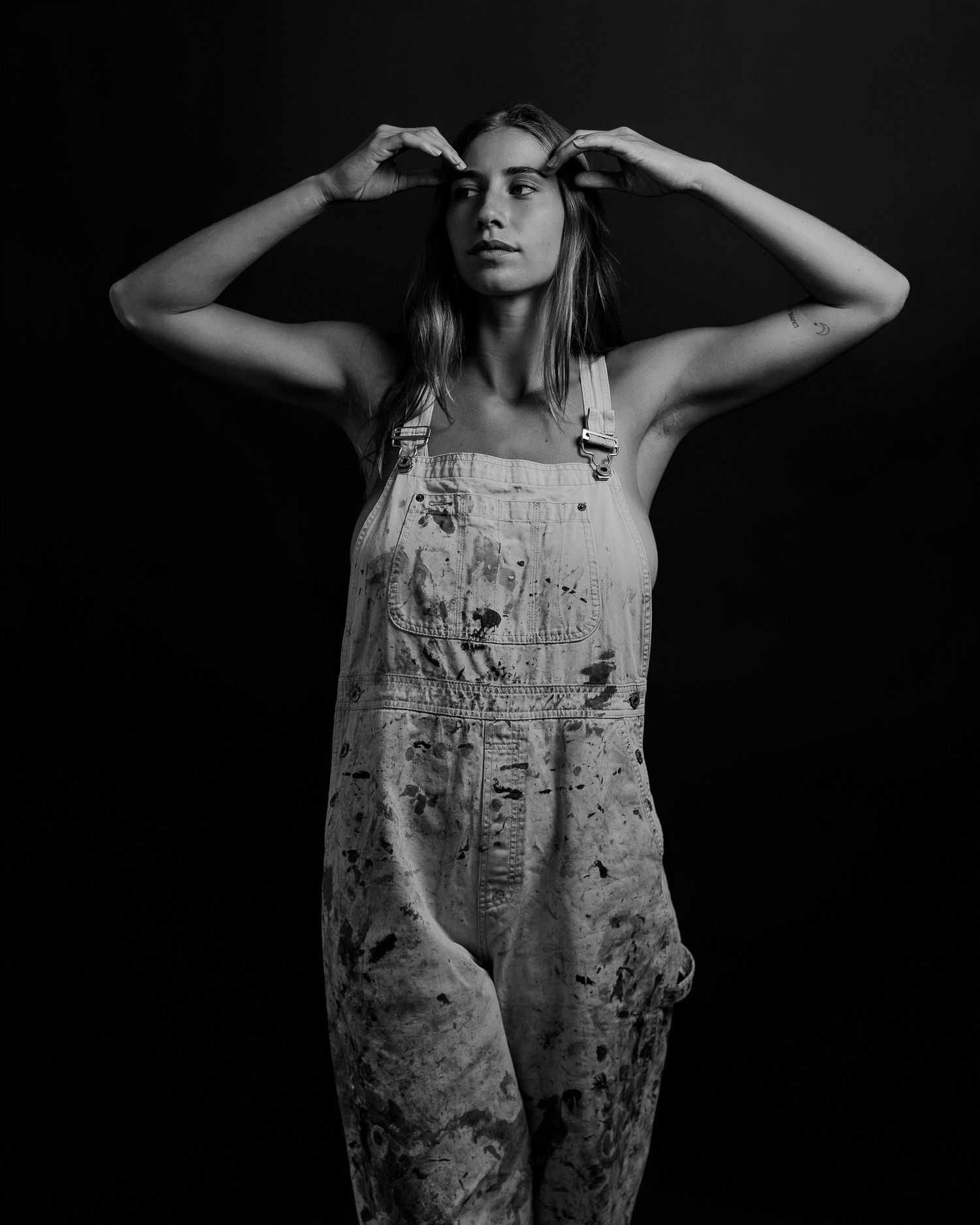 Artistic portraits showing paint-covered overalls in dramatic black and white.