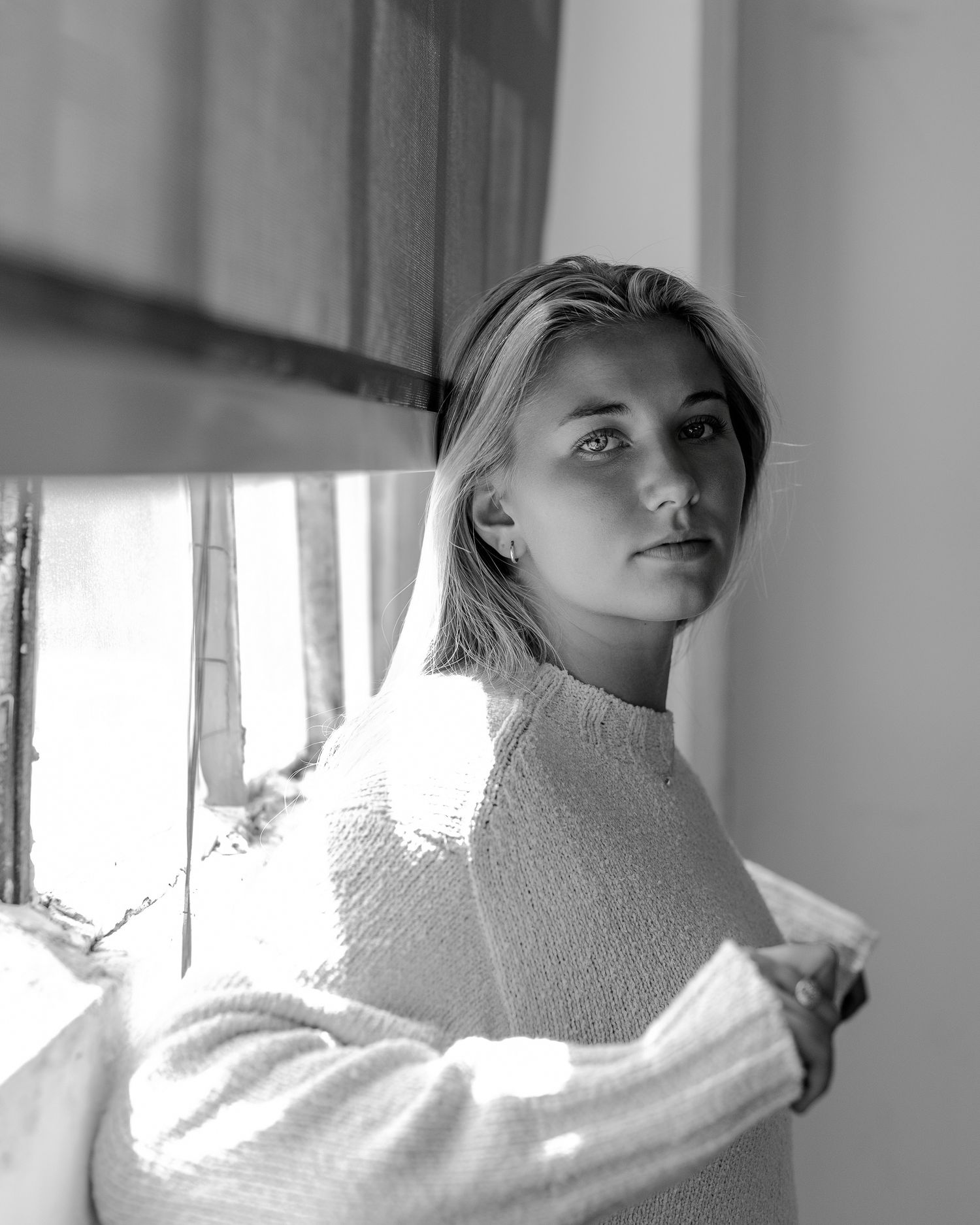 Artistic black and white series featuring soft window light and a white turtleneck sweater.