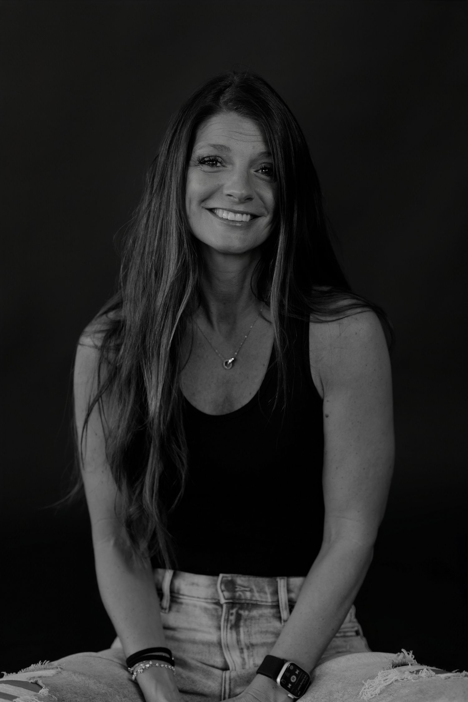 Artistic black and white photo featuring casual poses in dark setting.
