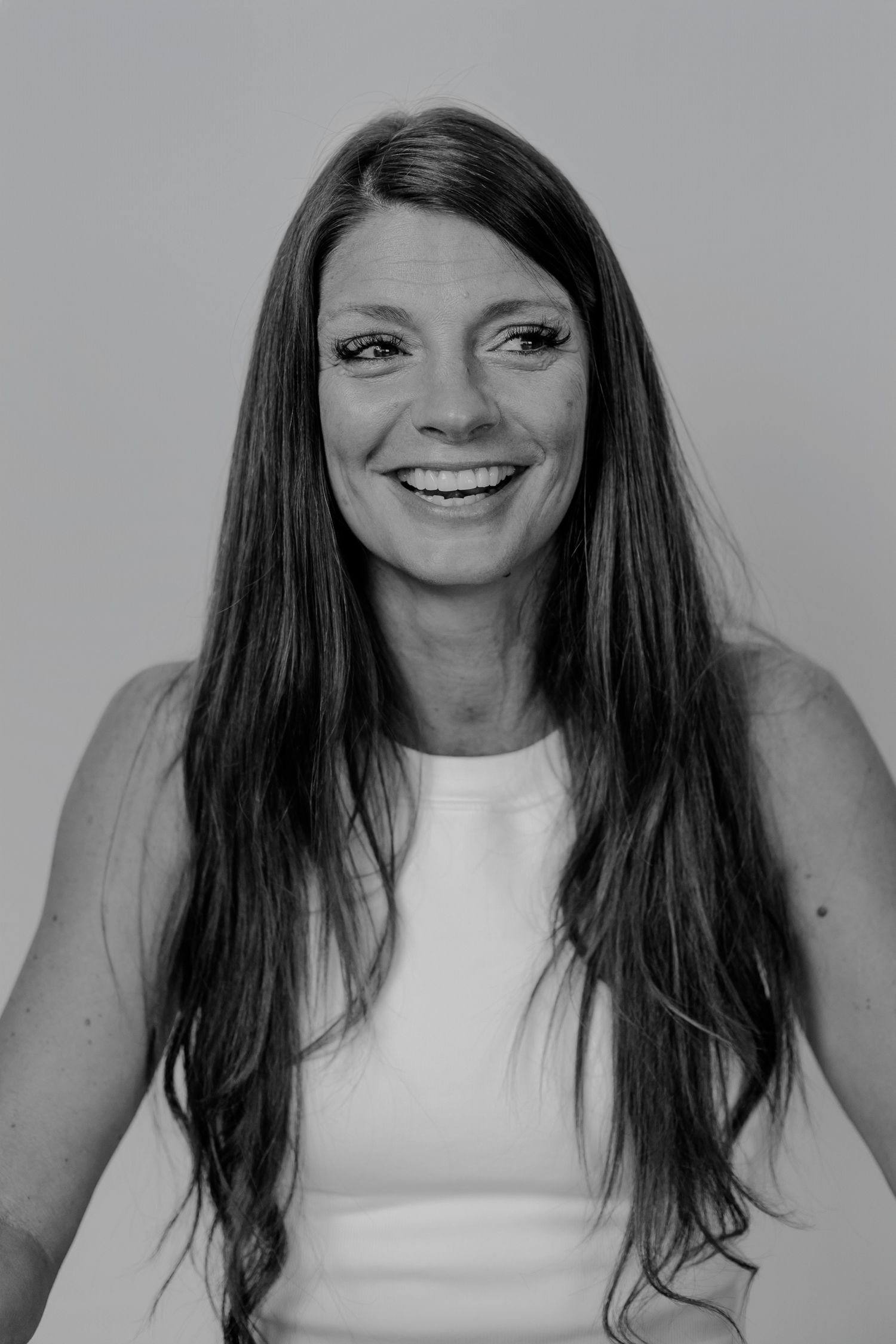 Black and white photo sequence showing progressive smiles in white sleeveless top.