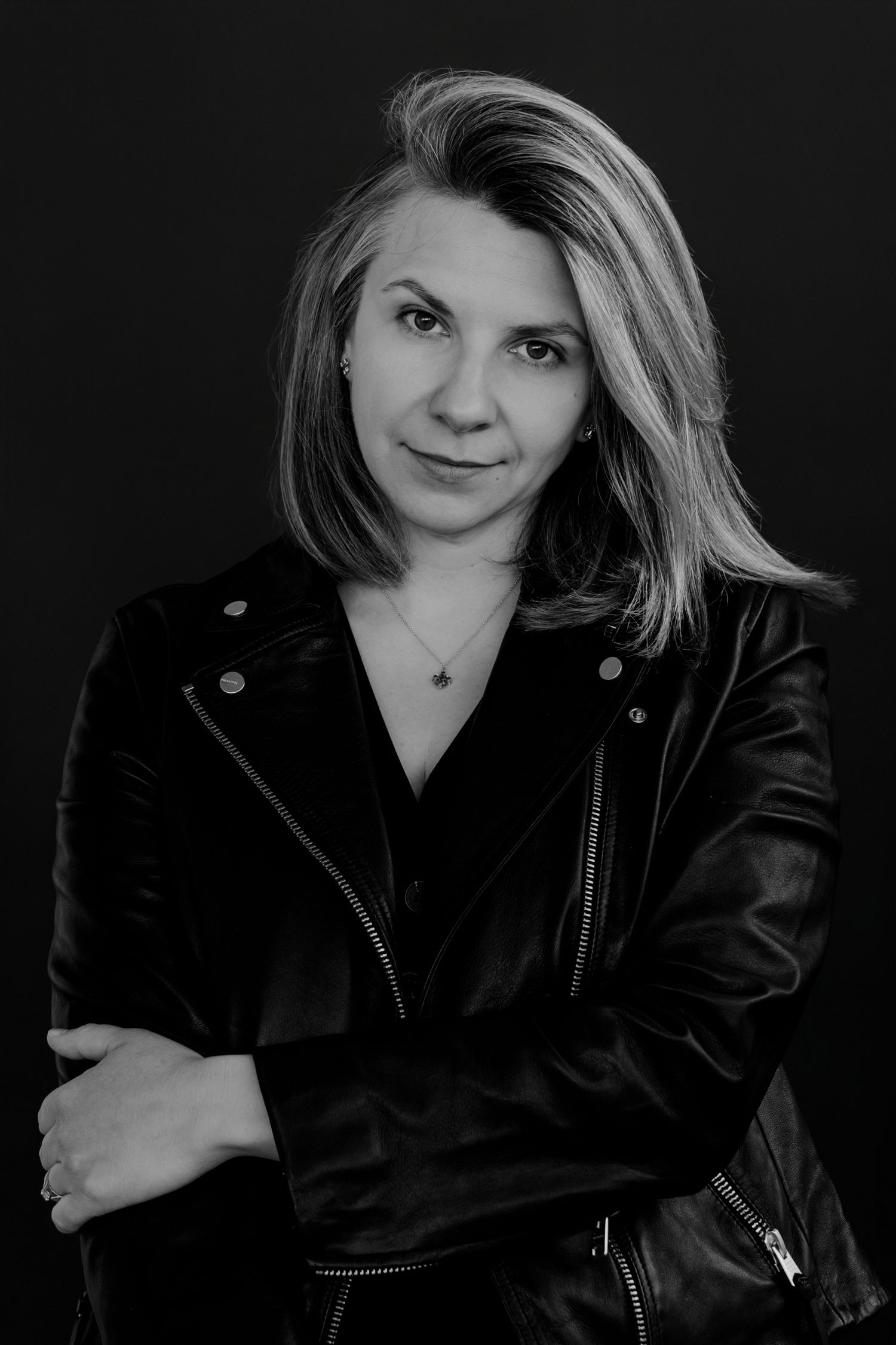 Dramatic black and white portrait series showing person in leather jacket against dark background.